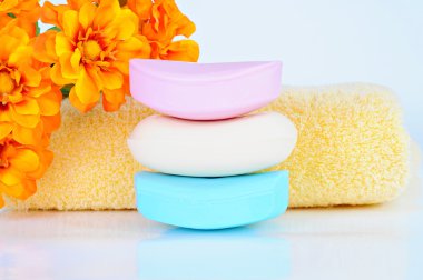 renkli sabun barlar, sarı havlu, turuncu çiçekler