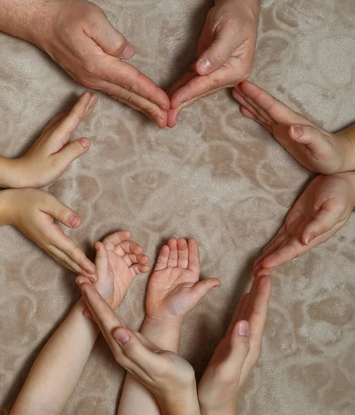 Pais e criança segurando o coração vermelho nas mãos, close-up. Dia da família — Fotografia de Stock