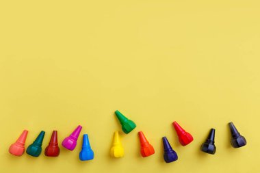 Çocuklar parlak sarı arka planlara pastel boya sürerler. Üst görünüm.