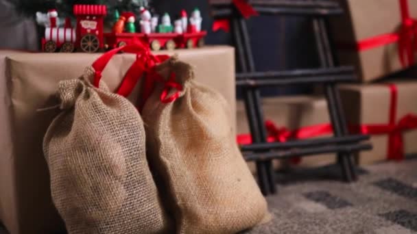 Karácsonyi dekorációk és ünnepi ajándékok piros szalaggal. Üdülési koncepció. — Stock videók