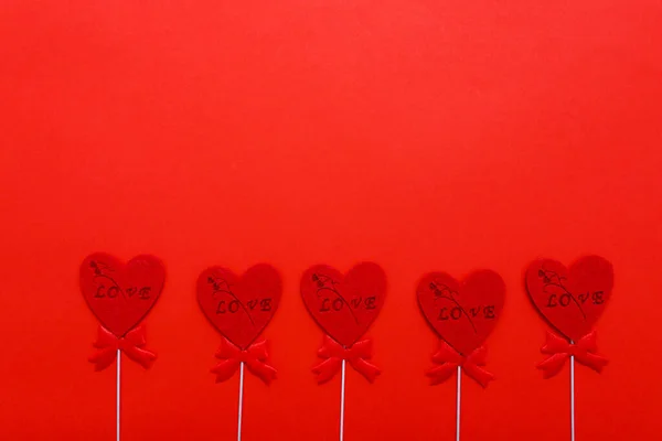 Красные сердца на красном фоне на День Святого Валентина. Праздники, любовь и романтика — стоковое фото