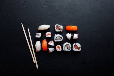 Japon suşi yemeği. Maki ve rulo ton balığı, somon, karides, yengeç ve avokado. Çeşit çeşit suşinin üst görünümü.