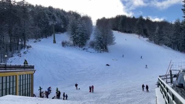 Beaucoup de gens descendent skier sur des pistes de ski parfaitement entretenues dans la station de ski — Video