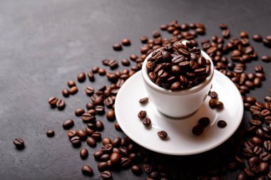 Sabah menüsü için süt köpüklü sıcak sade kahve beyaz seramik bardakta kahve çekirdekleri kavrulmuş.