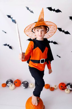 Cadılar Bayramı 'nda turuncu balkabağı ve Cadılar Bayramı kostümlü sarışın çocukla iyi eğlenceler.