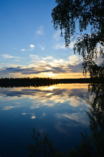 The midnight sun reflecting on a lake in Lapland, Finland during the summer solstice.