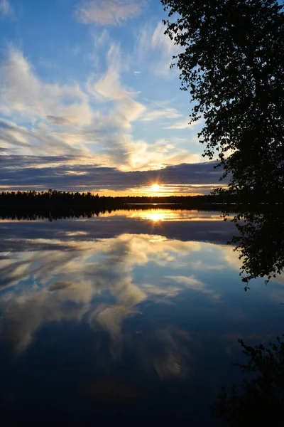The midnight sun reflecting on a lake in Lapland, Finland during the summer solstice.
