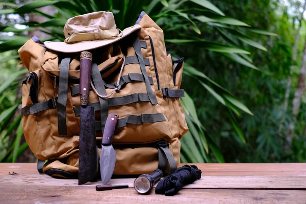 A knife with equipment for survival in the forest  on an old wooden floor