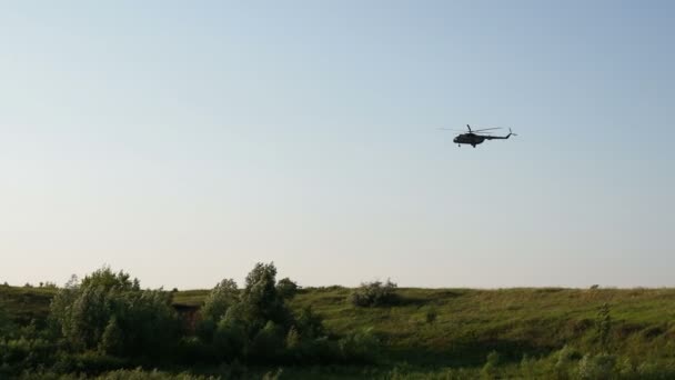 Vojenská helikoptéra letí nad polem a jezerem — Stock video