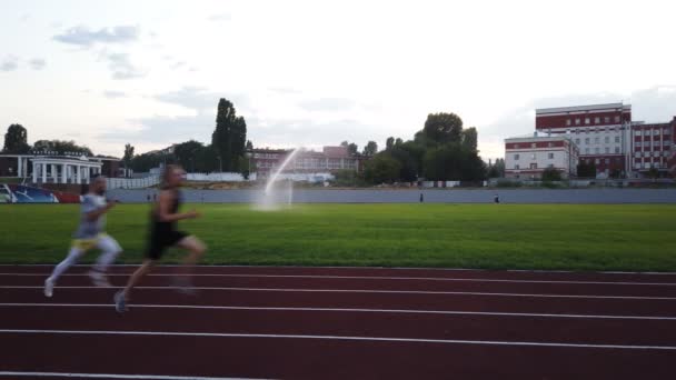 Saratov , RUSSIA - May, 2021: football field with running track in the evening,people do sports — Stock Video