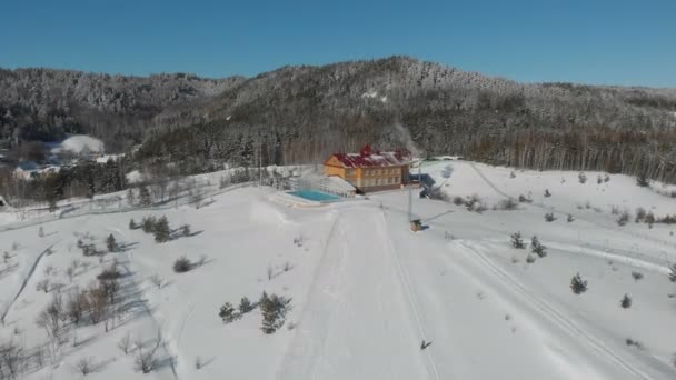 明るい晴れた日に高原の高山の山の冬のリゾート地の風景谷。圧雪のピセットでスキーやスノーボードを楽しむウィンタースポーツシーン。下り坂のパノラマの広い眺め — ストック動画