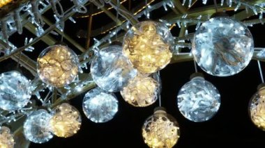 Kapanış görüntüsü, şehrin dışındaki güzel Noel kış dekorasyonlarının 4K videosu. İçinde parlak bir çelenk olan toplar.