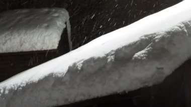 kalın kar tabakası seranın çatısını kapladı. Akşam kar fırtınası, ışığın altında kar yağıyor.