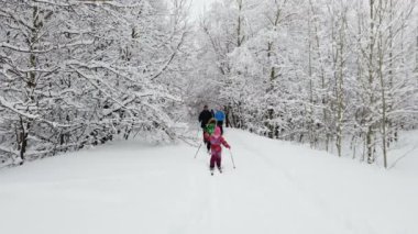 Saratov, Rusya - Ocak 2022: Aile kros kayağı güzel bir kış ormanında, ağır çekimde