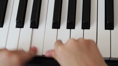 Piyano çalan bir çocuğun elinin yakın çekimi. Favori klasik müzik. Evde müzik öğretmek için müzik aletleri. Müzik aleti konsepti. Kendi kendini eğitme