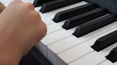 Piyano çalan bir çocuğun elinin yakın çekimi. Favori klasik müzik. Evde müzik öğretmek için müzik aletleri. Müzik aleti konsepti. Kendi kendini eğitme