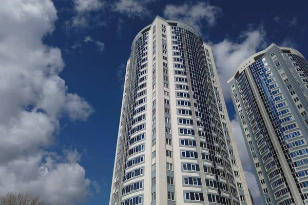 Oroszország, Saratov - 2021 április: két új gyönyörű felhőkarcoló a kék ég ellen, fehér felhőkkel — Stock Fotó
