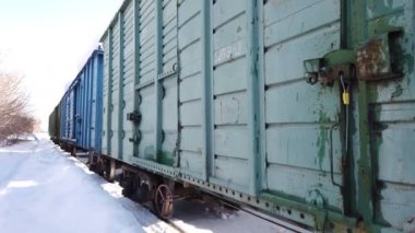 Kışın tren istasyonunda yük vagonları dolusu yük vagonu. Sovyet tarzı yük trenleri.