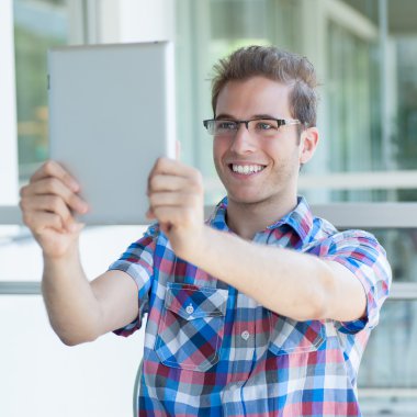 Genç gülen erkek tablet PC'yi kullanma