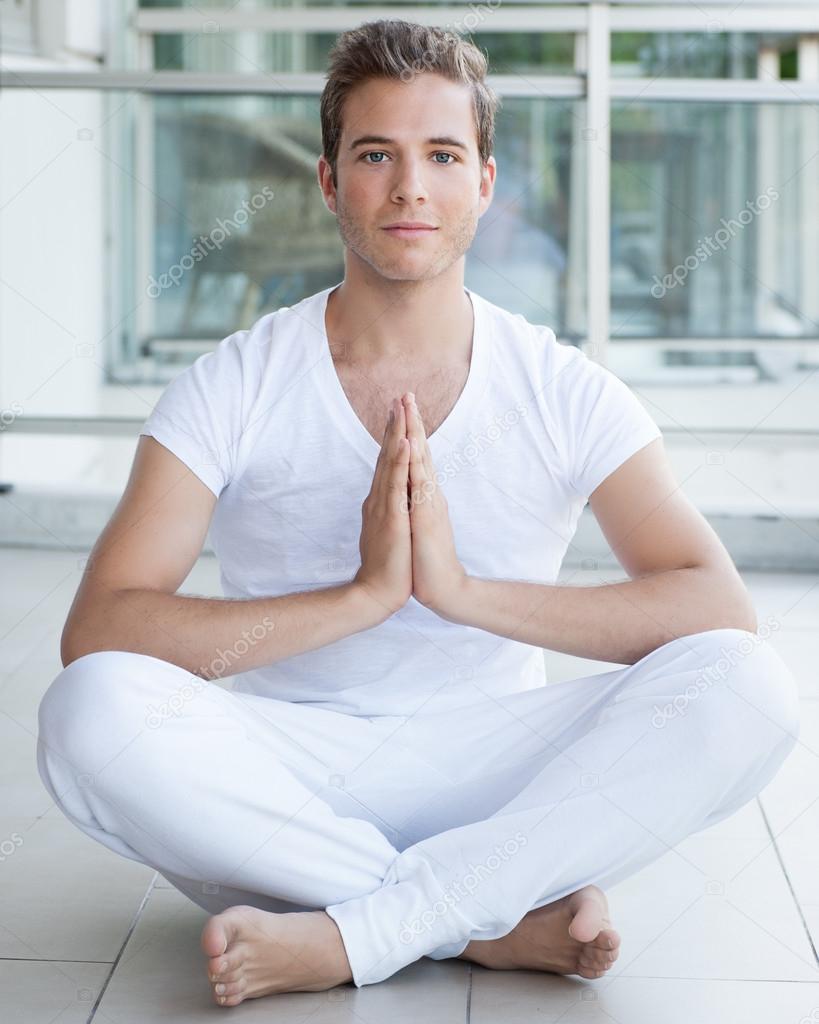 Young adult meditating with hands together