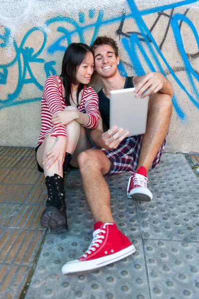 Junges multiethnisches Paar mit Tablet-PC. Stockbild