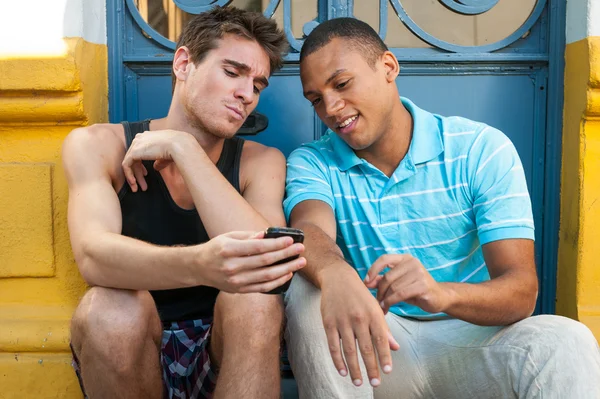 Fiatal férfiak birtoklás móka-val egy cellphone. Stock Fotó