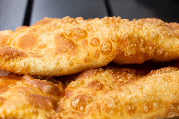 Les chebureks collent sur une table en bois macro, la texture de la pâte frite à l'huile. — Photo