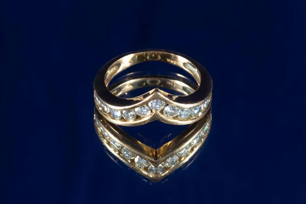 Sortija en oro amarillo con diamantes naturales sobre fondo azul, anillo de compromiso — Foto de Stock