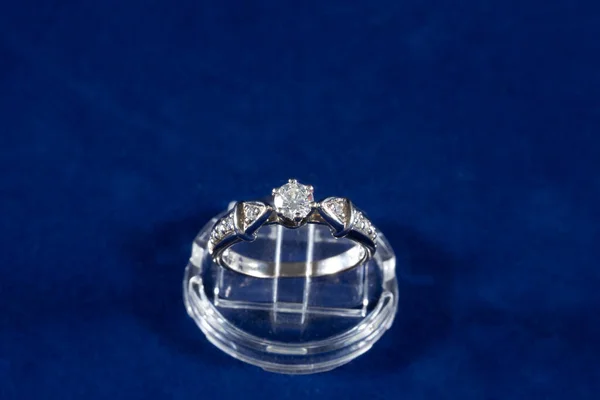 Anillo de oro blanco con diamantes naturales sobre fondo azul, anillo de compromiso — Foto de Stock