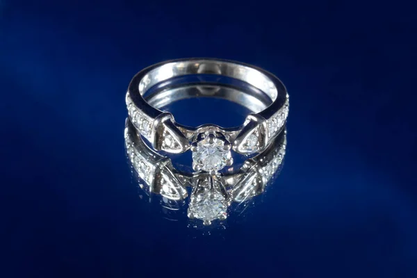 White gold ring with natural diamonds on a blue background, engagement ring — Foto Stock