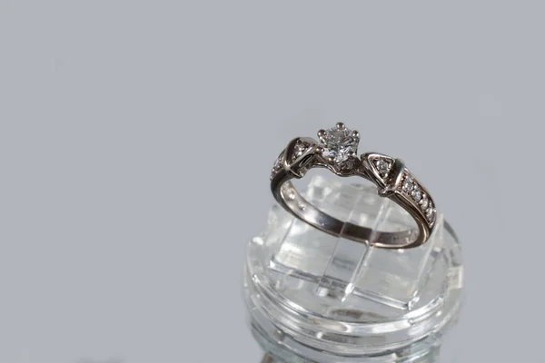 Anillo de oro blanco con diamantes naturales en un joyero sobre fondo gris — Foto de Stock
