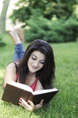 kız kitap ile çimenlerin üzerinde