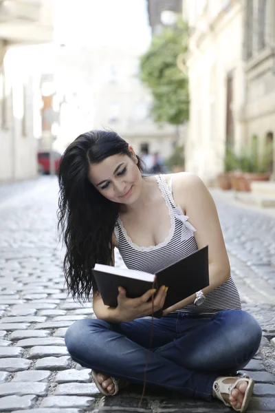 Chica lee libro en el camino —  Fotos de Stock