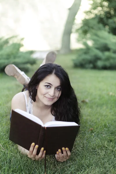 Menina na grama com livro — Fotografia de Stock