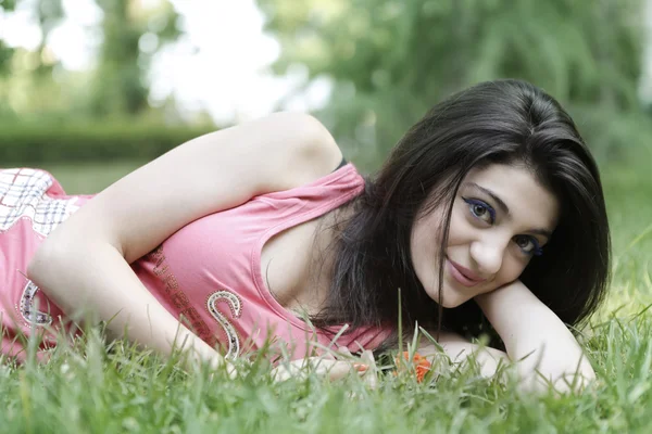 Dívka odpočívat na trávě Stock Obrázky