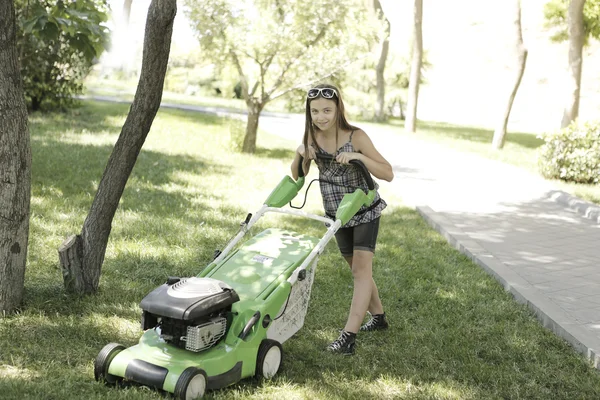 Flicka med gräsklippare Stockbild
