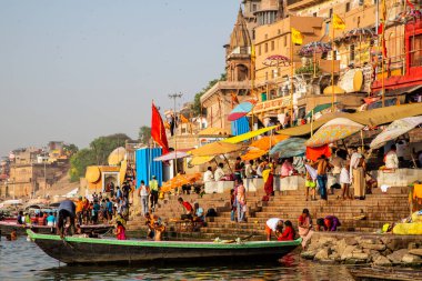 Varanasi, Hindistan - 18 ve 19 Nisan 2018: İnsanlar Hindistan 'ın Varanasi kentindeki Ganj nehrinin ghatlarında ruhani törenler yapıyor, yıkanıyor ve yıkanıyor.