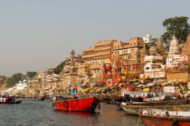 Showing the colorful traditional clothing and Hindu religious ritual of bathing in the holy Ganges River from the ancient ghats of Varanasi.