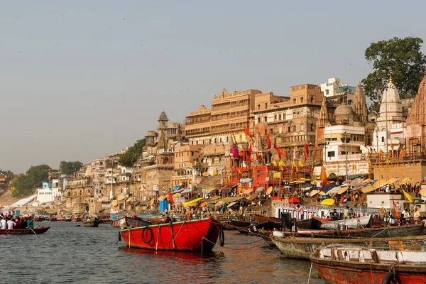 Showing the colorful traditional clothing and Hindu religious ritual of bathing in the holy Ganges River from the ancient ghats of Varanasi.
