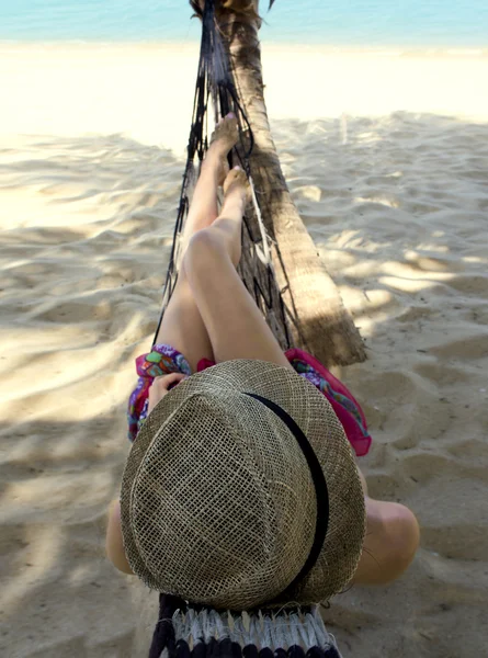 Slim young woman in a hammock wearing straw hat — Stock Photo, Image