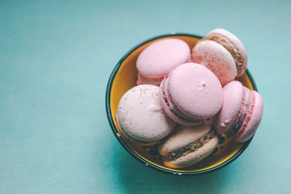 mavi zemin üzerine sarı bir kasede macaroons