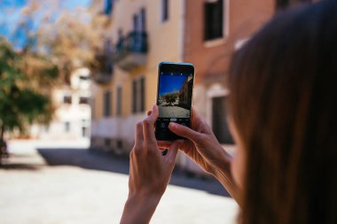 Hücre teknolojisi ve tatil. Venedik, İtalya 'da Instagram' da şehir manzarası için fotoğraf çeken akıllı telefonlu bir kadının elini kapatın.