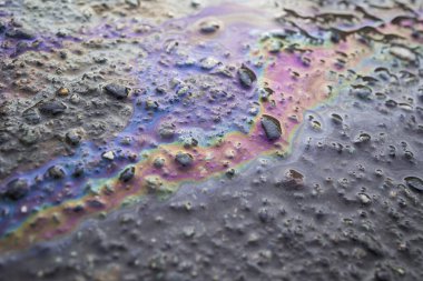 Asfalt yolundaki benzin lekesinin rengi bir doku ya da arkaplan olarak.. görünümü kapat 