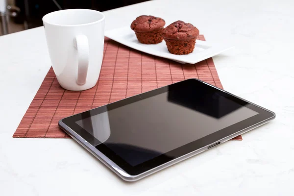 Muffin con gocce di cioccolato con una tazza di caffè e un tablet PC — Foto Stock