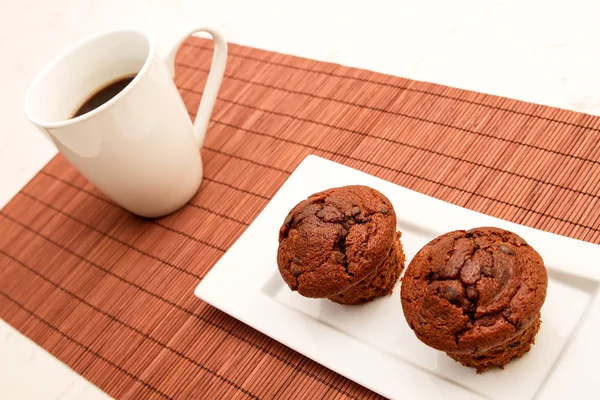 Muffins de chocolate con una taza de café —  Fotos de Stock