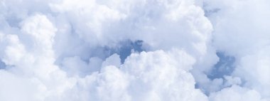 Güneşli havada beyaz bulutlu mavi gökyüzü. Kabarık gökyüzü bulutlu uçak penceresinden atmosfer.