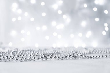 Yılbaşı ve Noel arkaplanı gümüş çelenklerle aydınlık ve bulanık. Kopyalama alanı ile gri nötr renkler