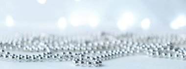 Pankart. Yılbaşı ve Noel arkaplanı gümüş çelenklerle aydınlık ve bulanık. Kopyalama alanı ile gri nötr renkler