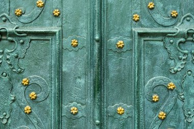 Old dark bright green metal door with pattern close-up. Vintage background.