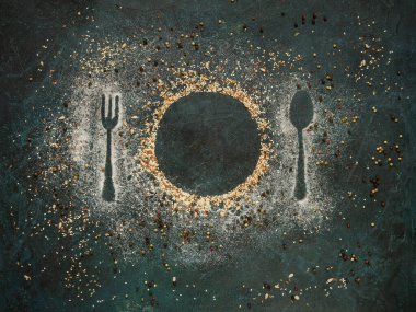 Susam tohumları, tuz ve keten tohumu ile yapılmış karanlık bir zemin üzerinde bir tabak ve çatal bıçak takımı. Baharatlar ve baharatlar. Yaratıcı natürmort.